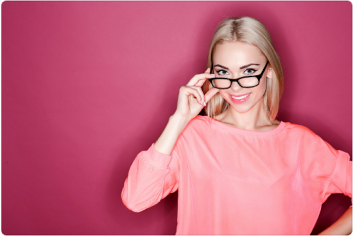 Mujer con lente multifocales y fondo rosa
